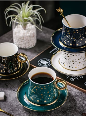 فنجان قهوة فاخر من السيراميك مع طبق تقديم وملعقة