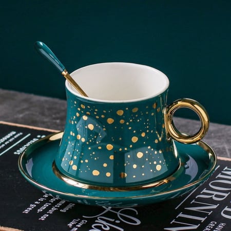 فنجان قهوة فاخر من السيراميك مع طبق تقديم وملعقة