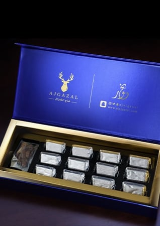 علبة زرقاء فيها بخور معمول ملون فضي مع عود في متجر بخور عاج الغزال