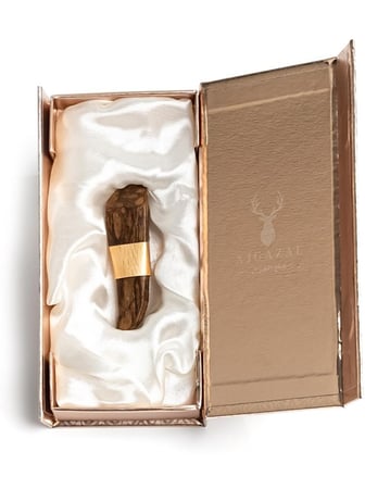 قطعة عود ملفوفة بورق ذهبي في صندوق فاخر مبطن بقماش أبيض من متجر الغزال