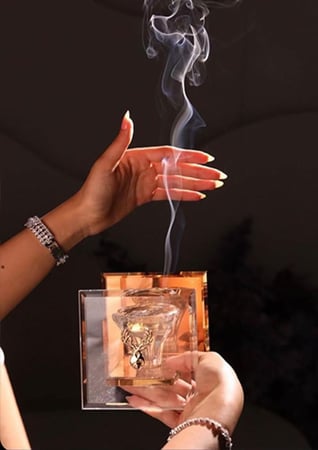 بنت تحمل مبخرة فاخرة زجاج فيها بخور من متجر مباخر عاج الغزال