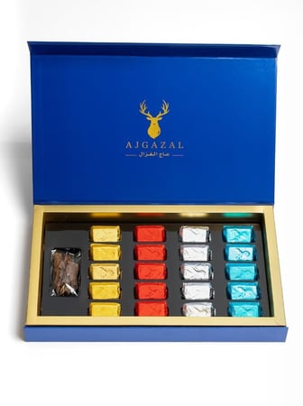 صندوق هدايا ازرق فيه معمول بخور ملون مع عود عليه شعار عا ج الغزال