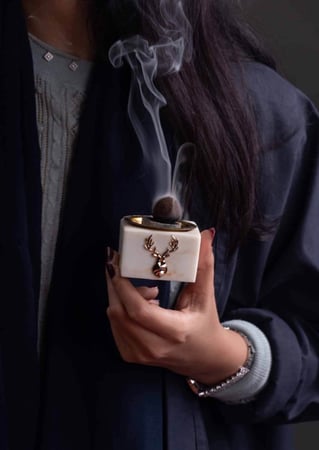 بنت سعودية تحمل مبخرة رخام صغيره فيها بخور من متجر مباخر عاج الغزال