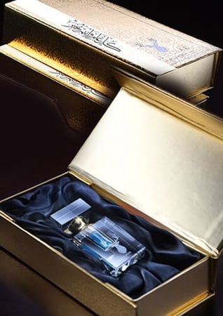 زجاجة توزيعات مسك في صندوق ذهبي مبطن بقماش أسود من متجر عاج الغزال