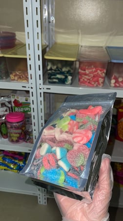 كيس جيلي متنوع من اسبانيا في يد عليها قفاز