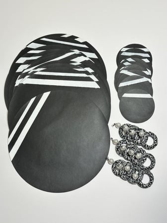 12 قاعدة للصحن مع قاعدات الكاسات مع خواتم المناديل يخدم 12 شخص باللونين ألأسود و طباعه بيضاء مع هديه اربع قاعدات كبيرة من الخشب مثل الموضحة في نصف الصورة