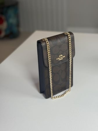 شنطة كوتش هاتف لميتد بلون بني سجنشر واسود NORTH/SOUTH PHONE CROSSBODY IN SIGNATURE CANVAS