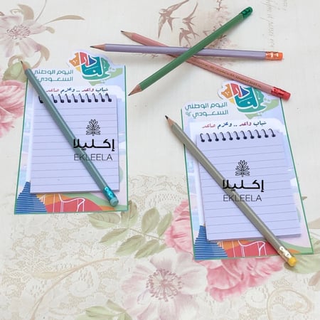 توزيعات نوته مع قلم رصاص بثيم ورقي لليوم الوطني  ( 12 قطعه )