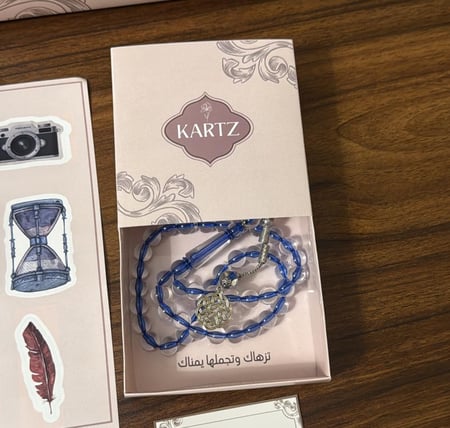 كيس KARTZ ورد صناعي أحمر مع مسبحه رجاليه