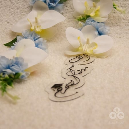 عقد زهور الأوركيد مع تعليقة ( الف مبروك التخرج )