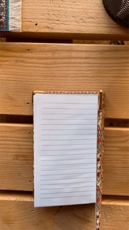 مُفكرة صغيرة بغلاف السجاد مزخرف احمر.