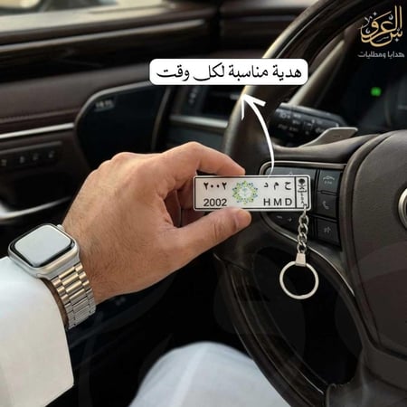 ميدالية مفاتيح لوحة الرؤية ممسوكة باليد داخل السيارة