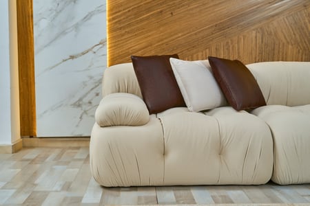 كنب زاوية فخمة ومريحة بتصميم كابوتنيه مع بف جلد أنيق