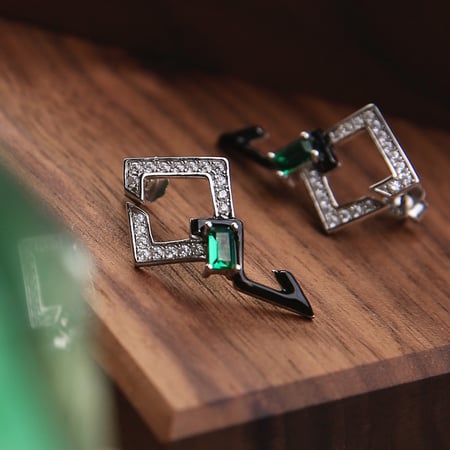 حلق بتصميم فريد مزيّن بالمينا السوداء والحجر الأخضر، ومطعّم بالزركون درجة ألماس