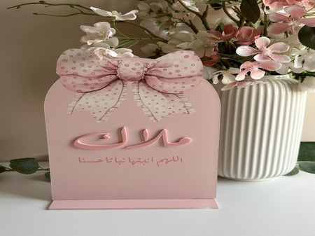 ستاند طاولة اكريلك للاسم / مع ثيم الفيونكة وكتابة بالاكريلك البارز