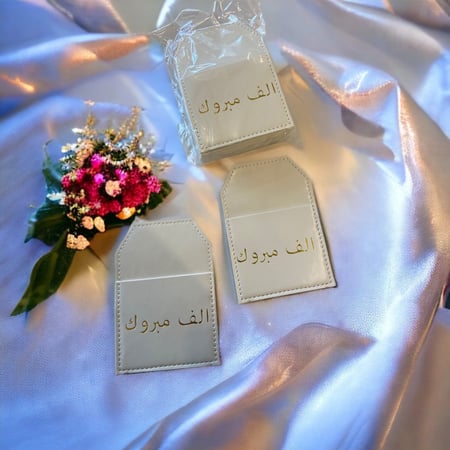 جيوب جلد أبيض بعبارة ألف مبروك12 حبه.