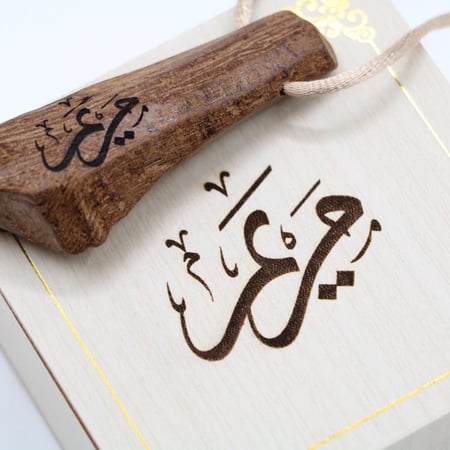 تعليقة قطعة من العود الفاخر منحوت عليها الاسم الذي يرغب به العميل