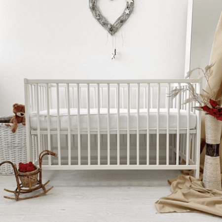 سرير اطفال باللون الابيض من الخشب الزان