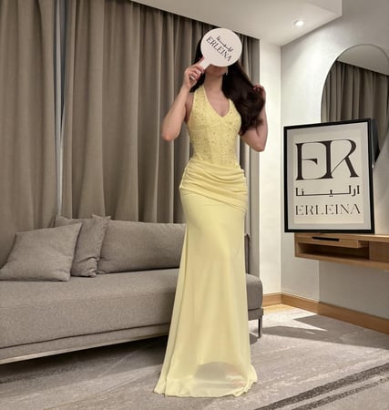 فستان لون اصفر بتفاصيل انثوية ناعمة تناسب السهرات