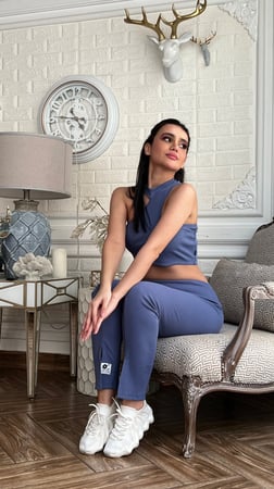 ترينق أزرق على موف رياضي بنطلون سكيني مفتوح من أسفل وبلوزة بدون كم بقصة مائلة من الكتف
