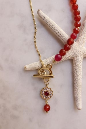 سلسله حجر عودي محمر مع تعليقه ورده زركون