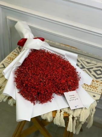 باقة ورد حمراء على شكل قلب بتغليف أبيض أنيق