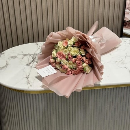 باقة ورد وردي وكريمي بتغليف وردي فاخر من هدايا رويال