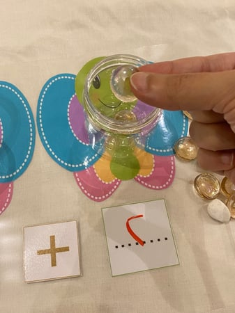 لعبة ثلاثة في واحد لمفهوم العدد ومدلوله ومفهوم الجمع ومفهوم الطرح ( لوحة قاعدة مقاس a4 مقوى يمكن الكتابة عليها بقلم سبورة مزودة بصورتي فراشة ، مساحة لكتابة العدد ، علامتي جمع وطرح مزودة بشك شكاك للتغيير ، علبتين شفافة بلاستيكية ، 20 قطعة احجار تأتي بالوان