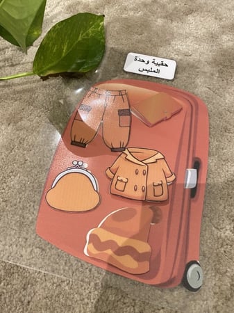 احجية مناسبة لوحدة الملبس تحوي قاعدة مقاس a4 مزودة بصورة حقيبة وشك شاك + 5 قطع لانواع الملبس مزودة بشك شاك جميعها طباعة ملونة ومغلفة حراريا