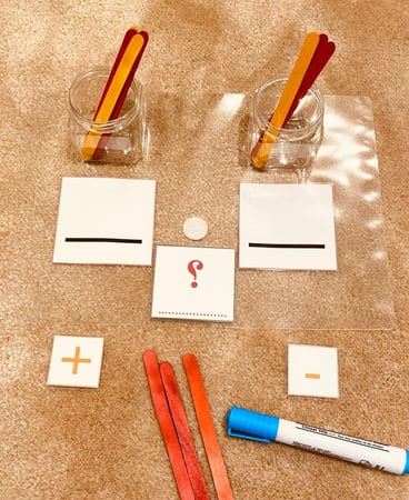 نشاط تعليمي لمفهومي الجمع والطرح معًا ( مقاس A4 ) طباعة ليزر ومغلفة حراريًا للحماية والكتابة والمسح عليها ، عبارة عن خانتين للأرقام + علامتي الجمع والطرح مزودة بشك شاك + علبتين بلاستيكية و 20 حبة من أعواد الايسكريم الملونة للعد + قلم سبورة