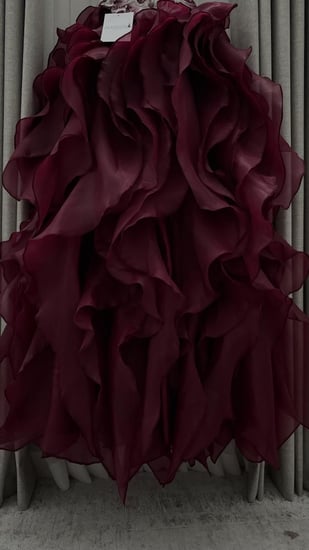 فستان سهرة عنابي بتوب مطرز وتنورة كشكش.