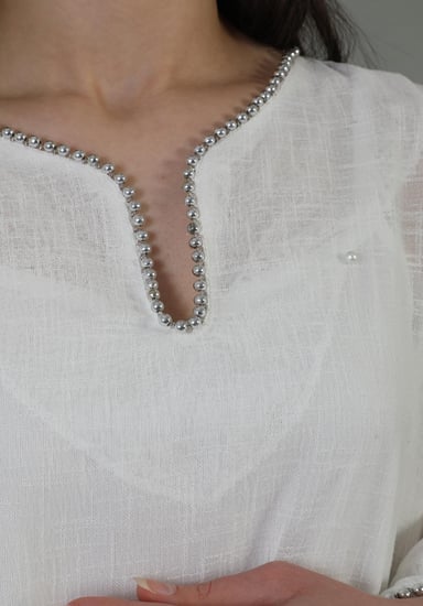 فستان صيفي أبيض بأكمام طويلة شفافة مزين بنقشة وياقة v