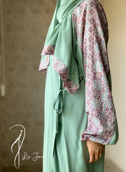 شرشف صلاة رسم باتيك لف اخضر و بنفسجي و الطرحة مثبتة .