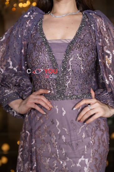 ستان سهرة موف أنيق مطرز بالكامل مع أكمام شفافة طويلة بتصميم فاخر يضفي لمسة ملكية مثالية لحفلات الزواج والمناسبات الخاصة.