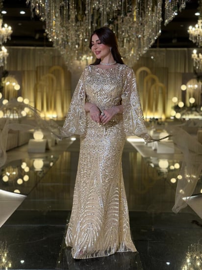 فستان لينا سهرة ذهبي فاخر مع تطريز يدوي وأكمام شفافة أنيقة، مثالي لإطلالة ساحرة