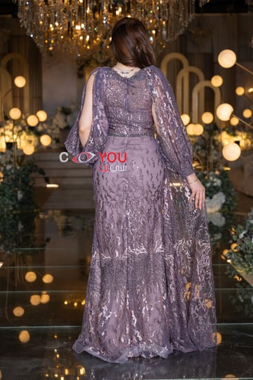 ستان سهرة موف أنيق مطرز بالكامل مع أكمام شفافة طويلة بتصميم فاخر يضفي لمسة ملكية مثالية لحفلات الزواج والمناسبات الخاصة.