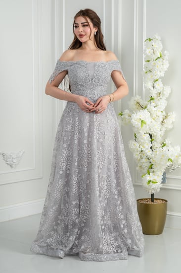 فستان سهرة فضّي أوف شولدر بلمعة راقية يوازن بين النعومة والحضور.