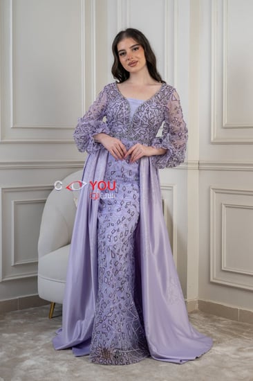 فستان بنفسجي فاخر مطرّز بأكمام منفوشة، تصميم أنثوي ملكي يبرز القوام بلمسات ناعمة وتفاصيل لامعة مناسب للأفراح والمناسبات الراقية.