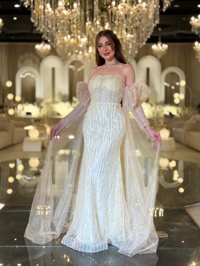 فستان سهرة ذهبي فخم بتطريز لامع وأكمام شفافه منفوشة ومنسدله بلمسة راقية