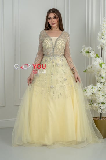 فستان سهرة أصفر باستيل مطرز بالترتر مع أكمام شفافة طويلة