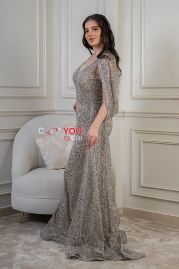 فستان سهرة مطرز فاخر بلون الشامبين بقصة أنيقة وذيل راقٍ.