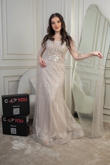 فستان سهرة فخامة شامبين مخمومة بلمعٍ رقيق؛ قصّة عمودية تُنحّت القوام وكاب مرصّع