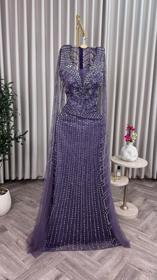 فستان سهرة بنفسجي، مطرز ببريق ناعم يعكس الفخامة،أكمام شفافة تمنحك حضورًا أنيقًا ولمسة من السحر والجاذبية.