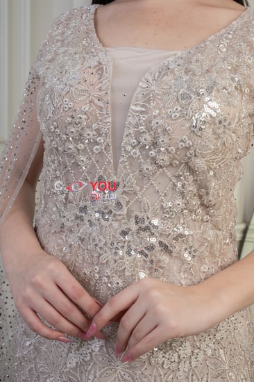 فستان سهرة فخامة شامبين مخمومة بلمعٍ رقيق؛ قصّة عمودية تُنحّت القوام وكاب مرصّع