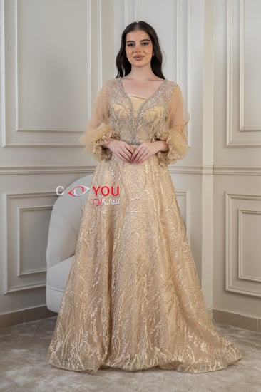 فستان سهرة ذهبي راقٍ بأكمام شفافة وتطريز ملكي - تصميم فخم وأناقة لا تُضاهى.