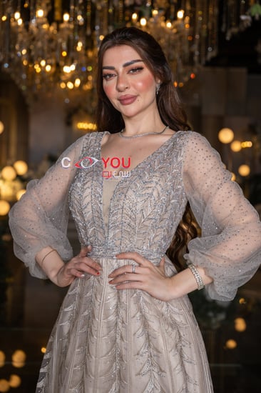 فستان سهرة بيج مطرز بتفاصيل فاخرة مع أكمام طويلة منفوشة بتصميم ملكي أنيق
