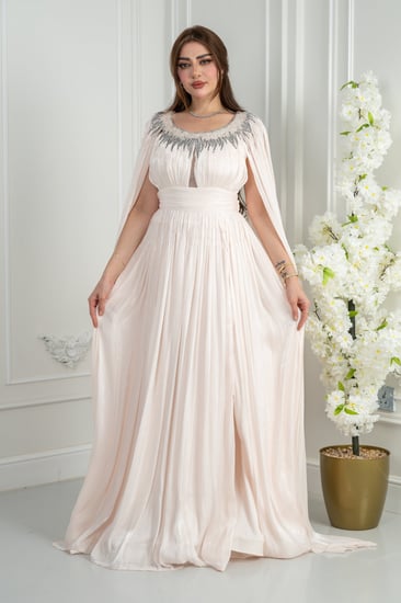 فستان سهرة أوف وايت يفيض نعومة ملكية. قماش حريري مطوي يلتقط الضوء بانعكاس ناعم مع كل حركة.