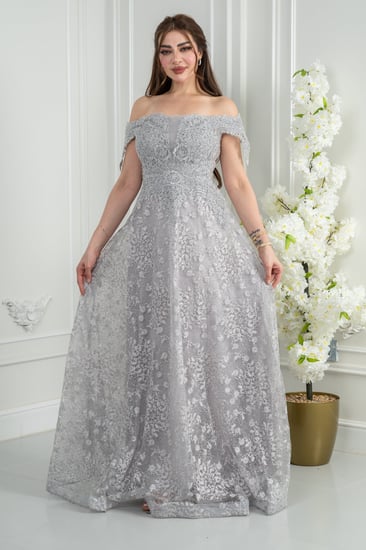 فستان سهرة فضّي أوف شولدر بلمعة راقية يوازن بين النعومة والحضور.