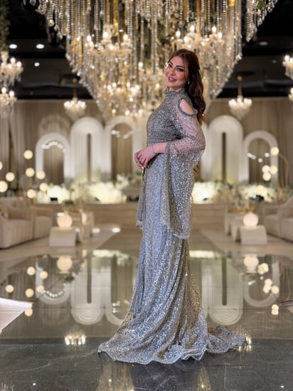 فستان سهرة تستحقّين فستانًا يلمع بقدرك هذا السيلفر المطرّز بالكامل برقبة عالية وأكمام كاب متدفّقة صُمّم ليبرز جمالك برقيّ