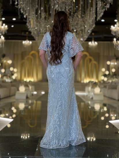 فستان سهرة سماوي لامع بطبقة كاب راقية تصميم يعانق القوام بانسيابية يبرز جمالك ويخطف الأنظار